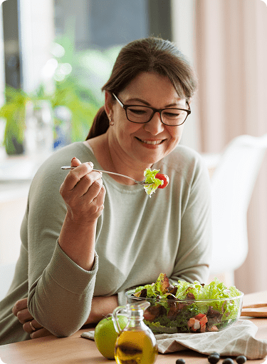 Woman enjoying a fresh salad at home.